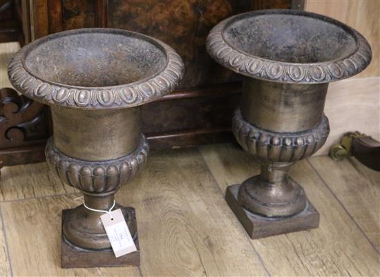 A pair of cast iron urns W.26cm